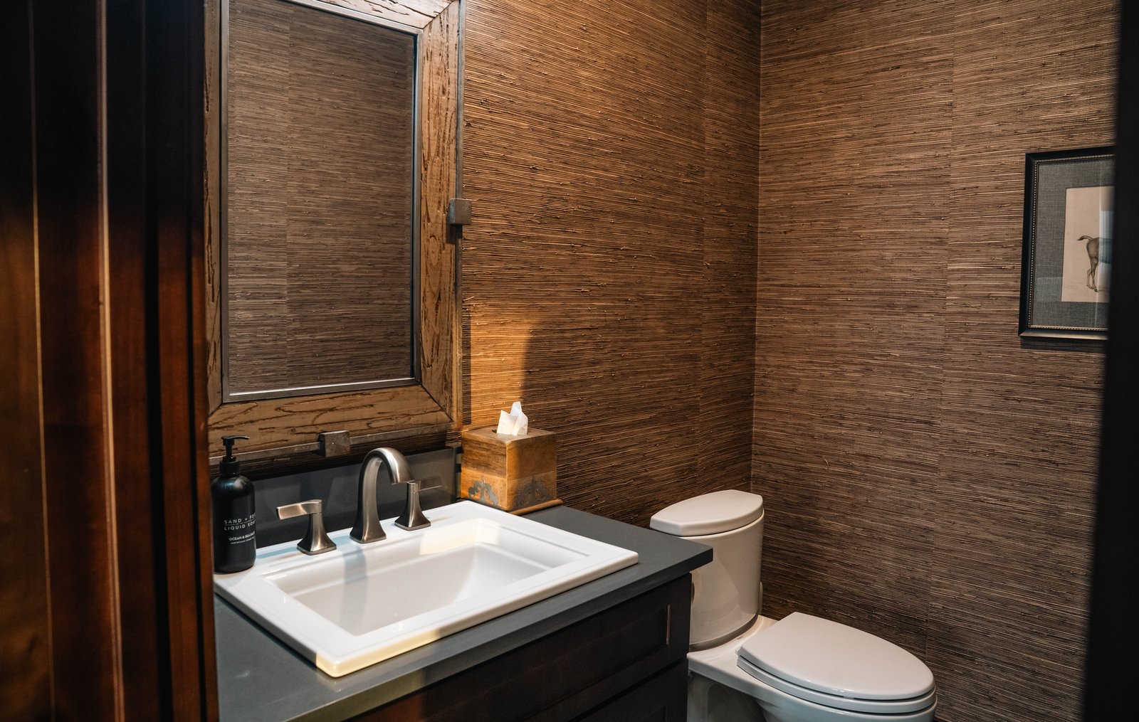 Guest bathroom finished in grasscloth and stone